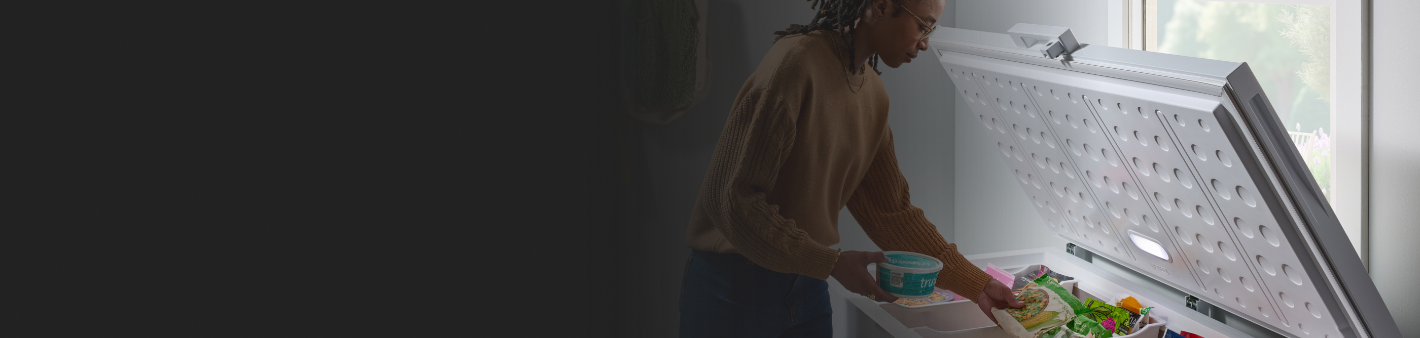 Person placing groceries in a deep freezer