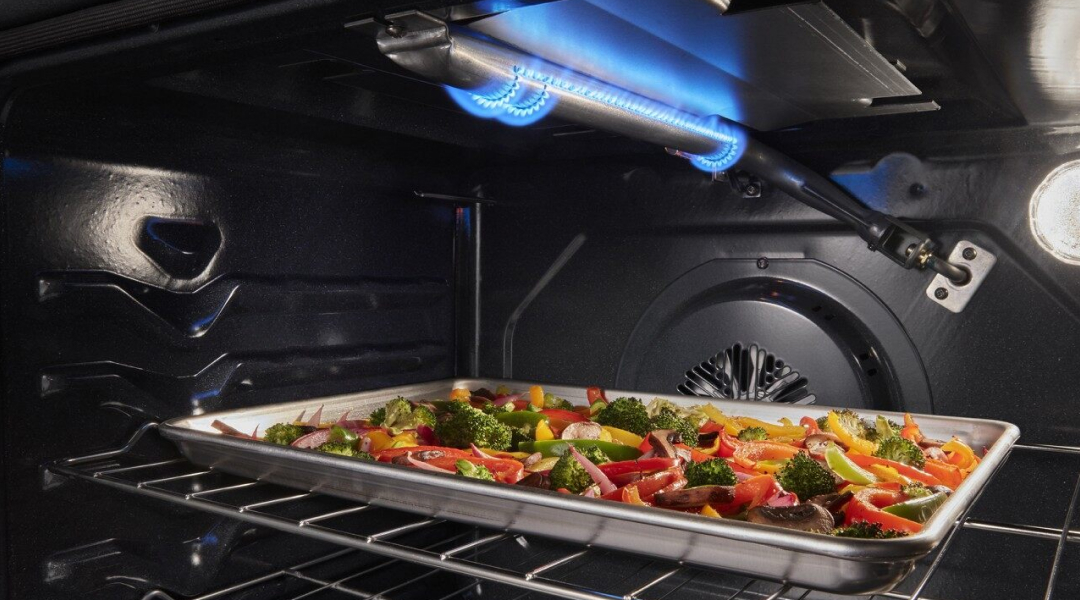 Sheet pan of roasted vegetables under a broiler element