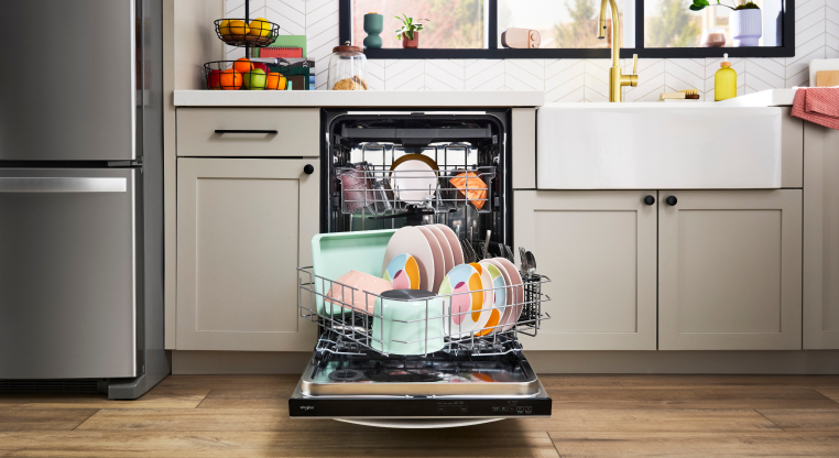 The Spin&Load Rack installed in a dishwasher, filled with colorful dishware 