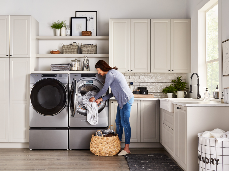 Woman loading laundry in a stainless steel Whirlpool® dryer