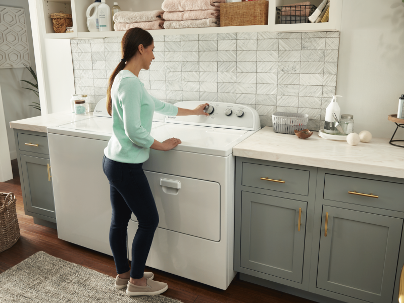 Person selecting a cycle setting on a Whirlpool® dryer