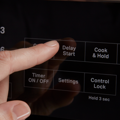  A person selecting the Delay Start option on an oven