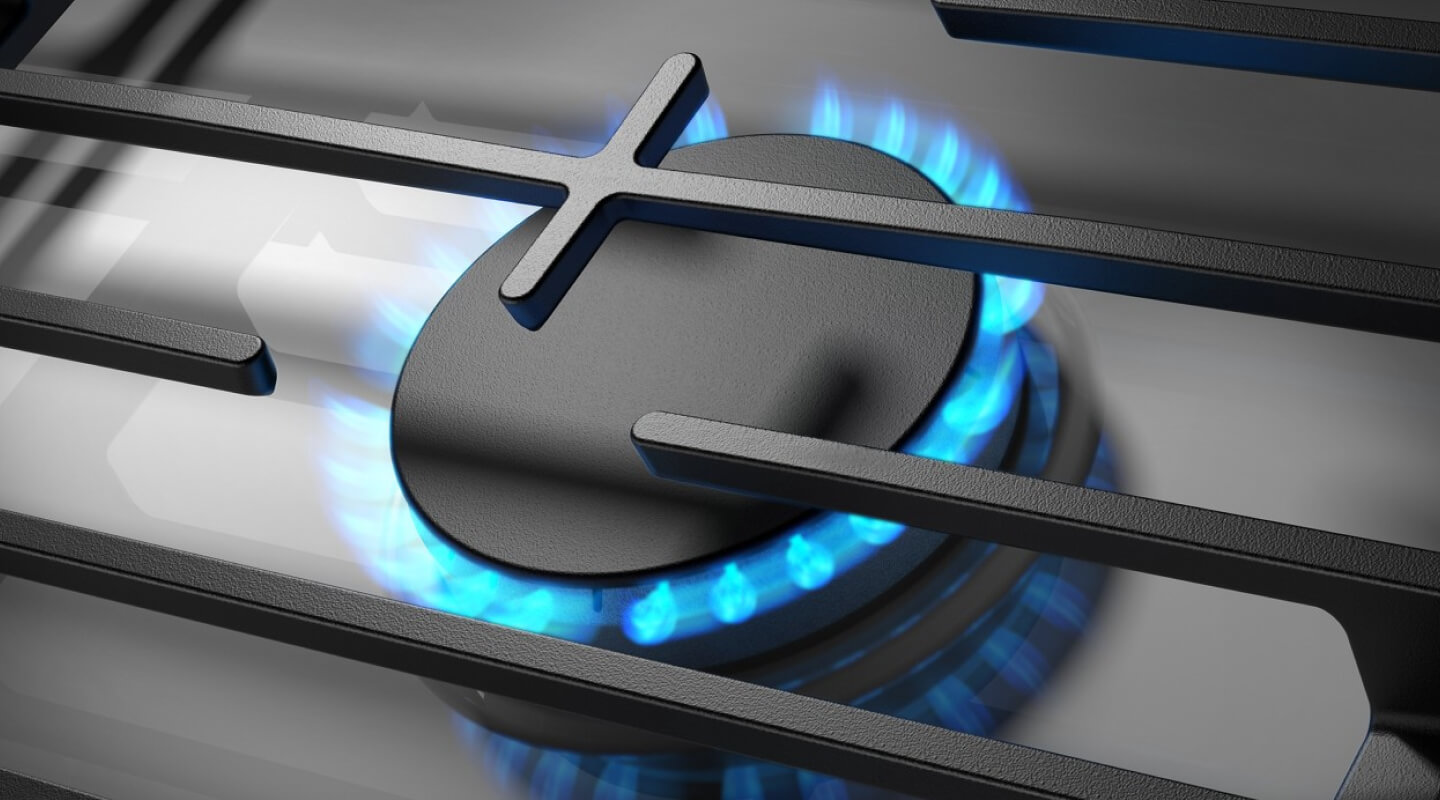 Close-up of blue flame on from a gas cooktop burner