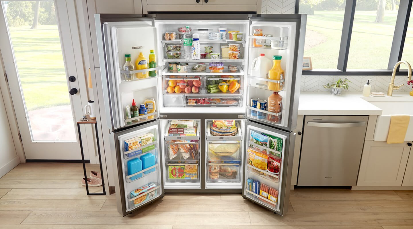 Fully stocked, open 4-door refrigerator built into tan cabinetry