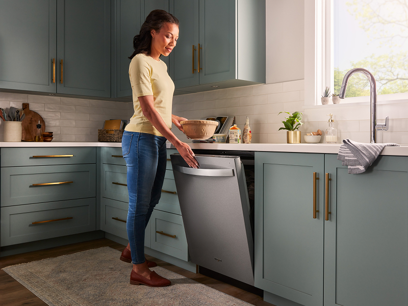 Person closing a top control dishwasher
