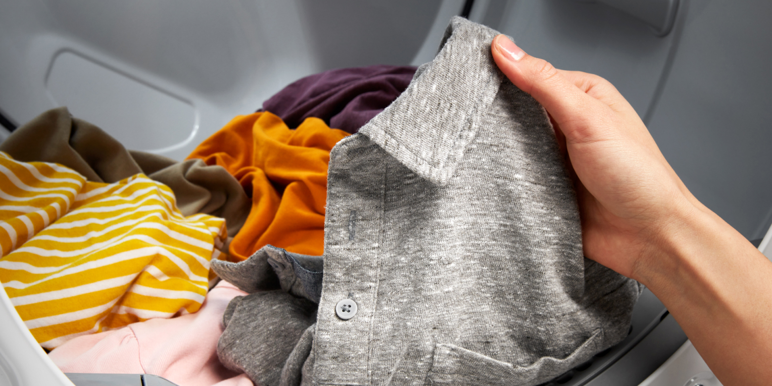 Hand taking a polo shirt out of dryer