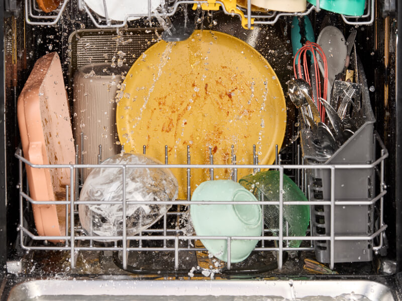  Dirty dishes being washed in a dishwasher