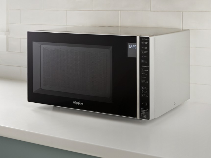 Whirlpool® Countertop Microwave in front of white backsplash