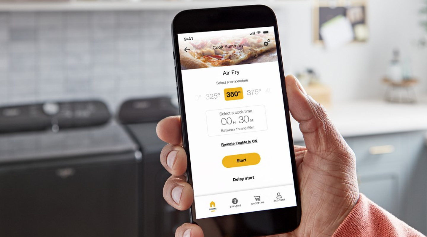 Person using a smartphone to monitor air fry temperatures in their Smart Microwave Oven from Whirlpool brand