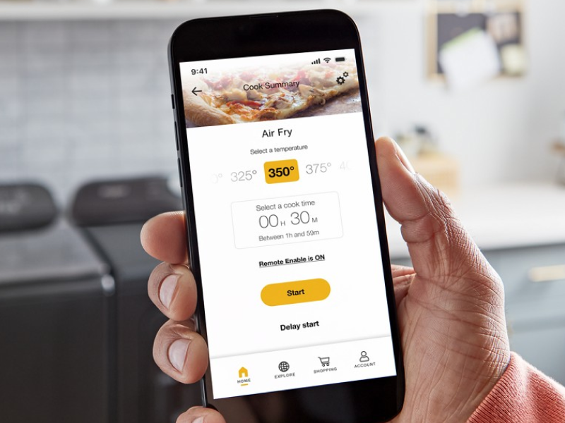Person using a smartphone to monitor air fry temperatures in their Smart Microwave Oven from Whirlpool brand