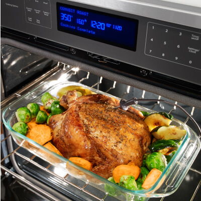Chicken and vegetables cooking in an oven