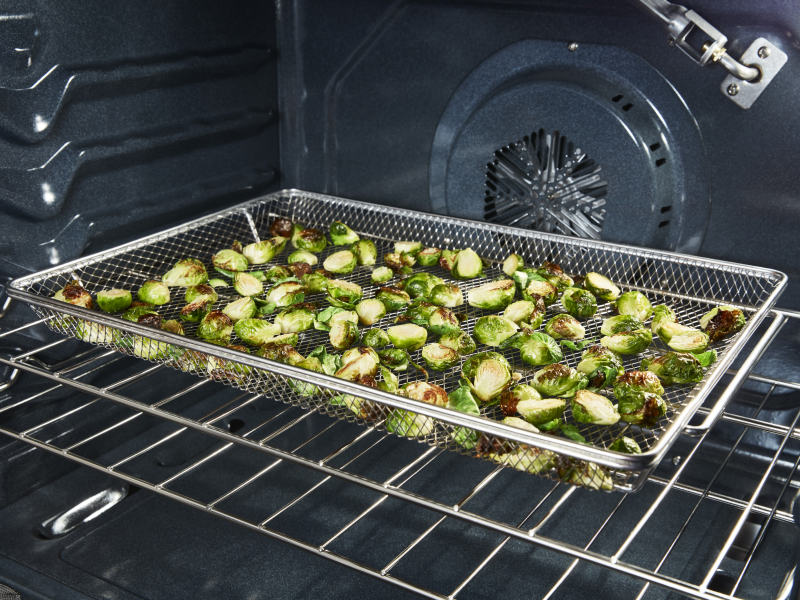 Zuccinni cooking in an air fry basket.