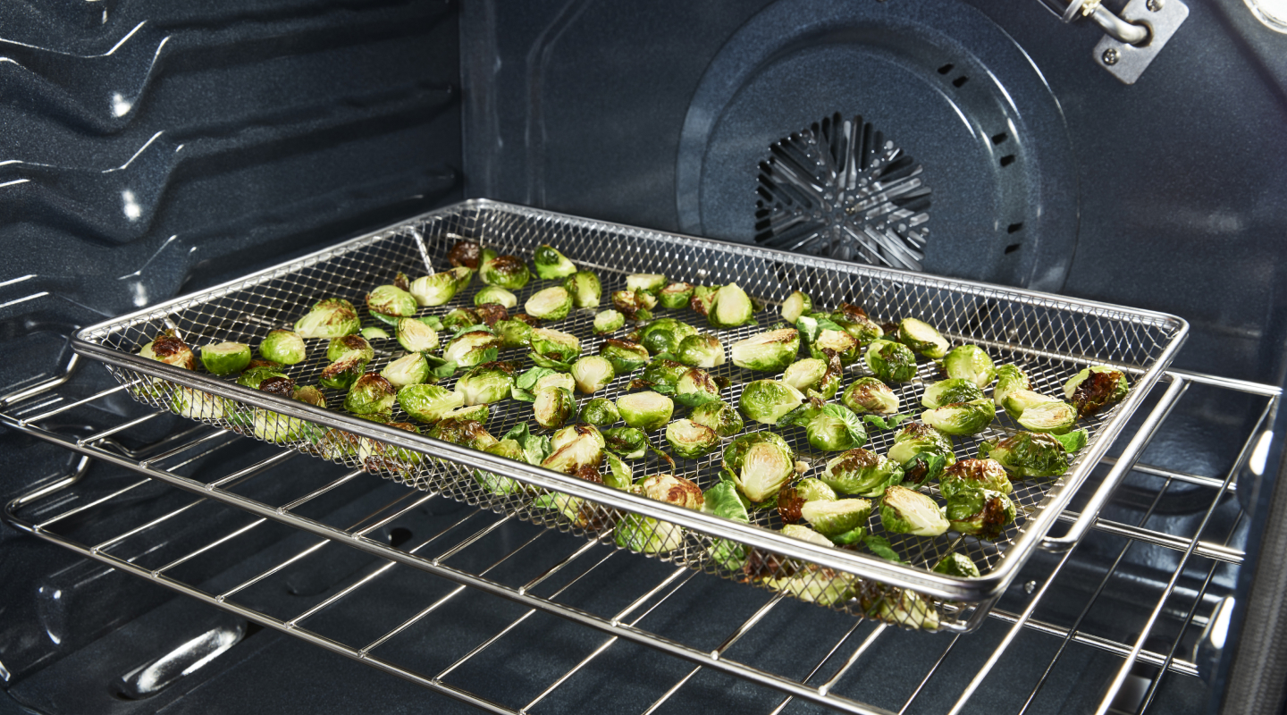 Zuccinni cooking in an air fry basket.