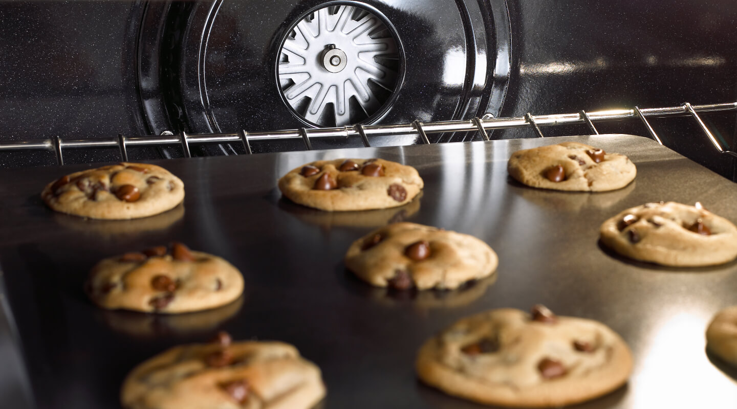 Chocolate chip cookies baking in an oven