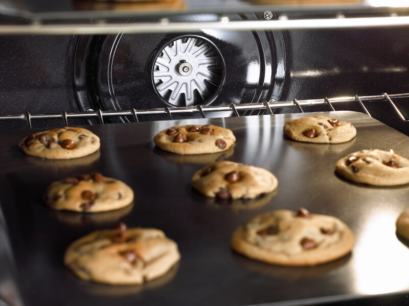 Chocolate chip cookies baking in an oven