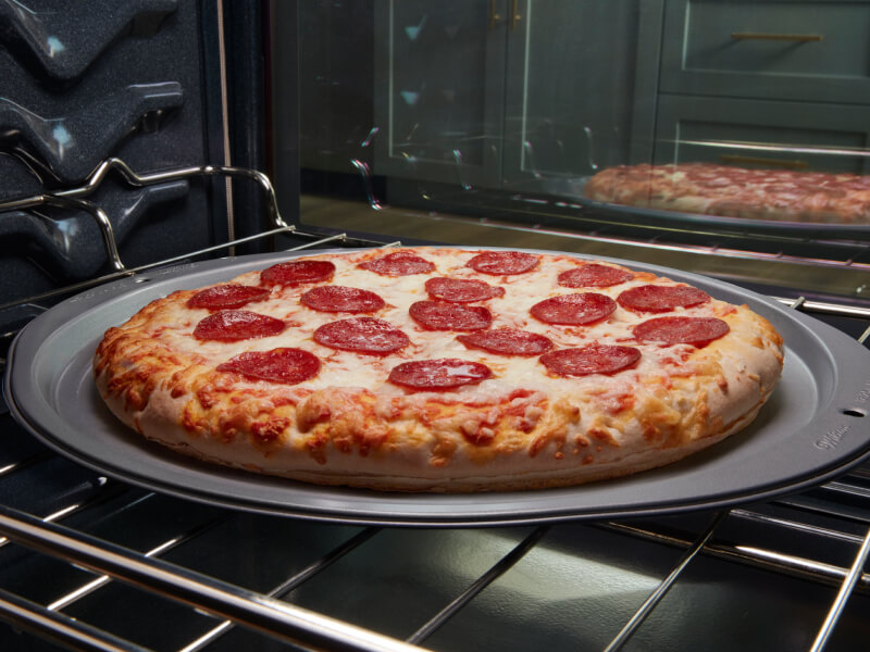 A pizza baking in an oven
