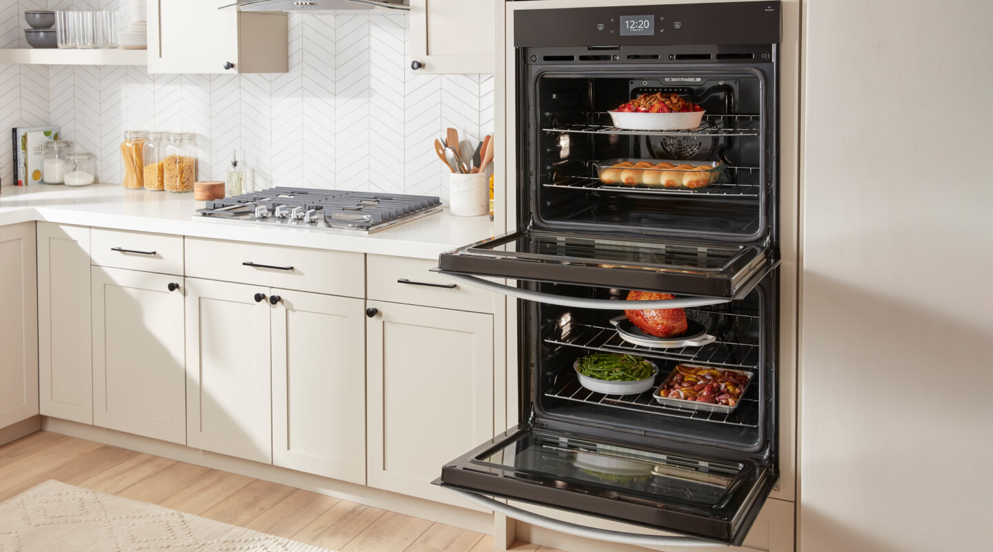 An open double wall oven with food cooking on every rack