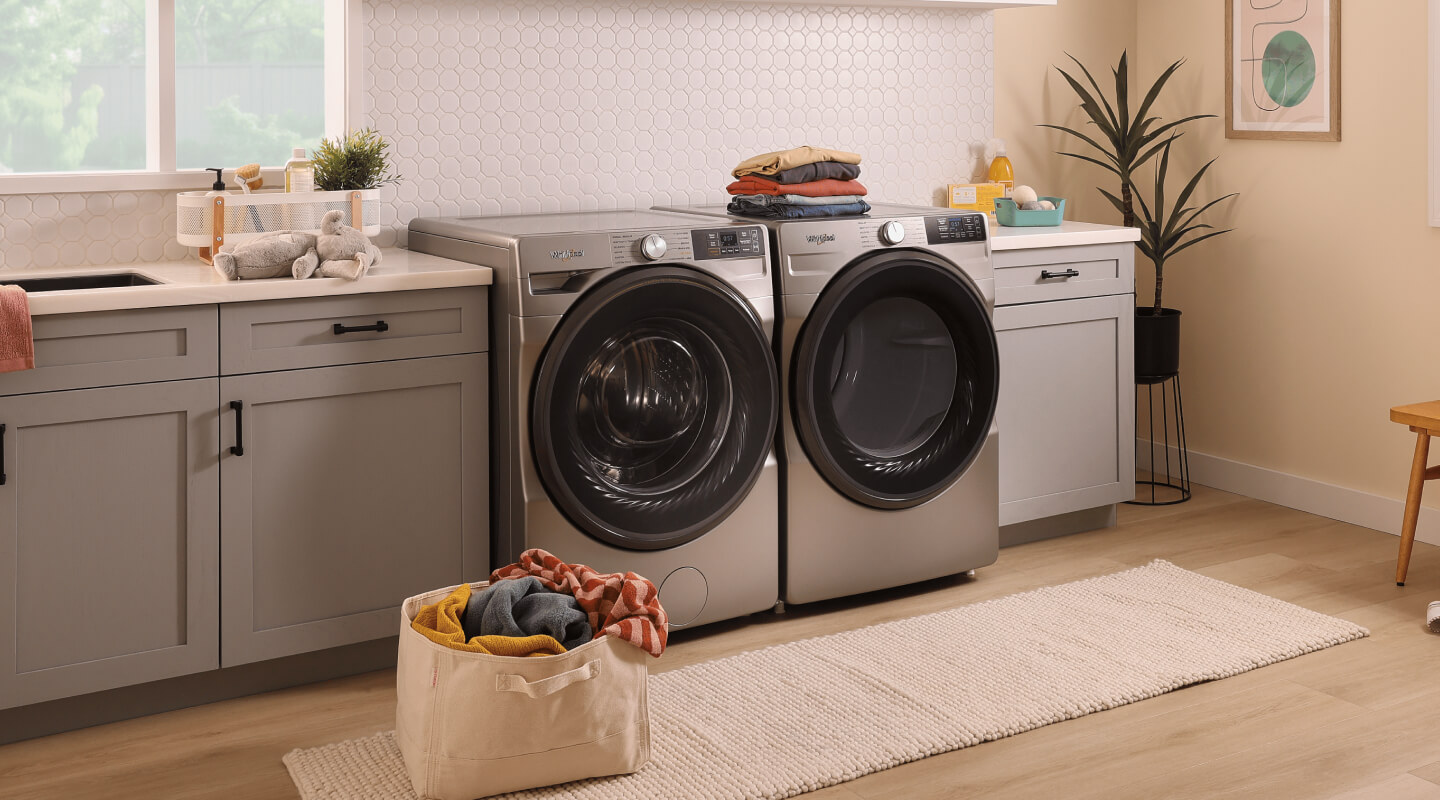 Front load washer and dryer set inside a laundry room