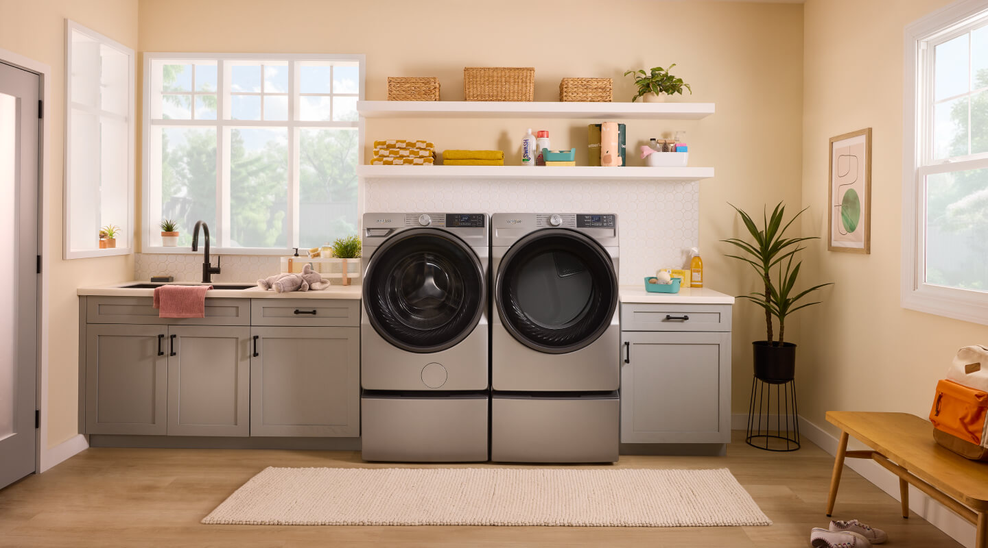Whirlpool® Front Load Washer and Dryer set on pedestals in open laundry room