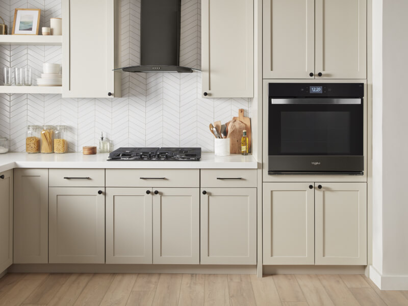 Whirlpool® Single Wall Oven and Gas Cooktop in kitchen with cream-colored cabinetry