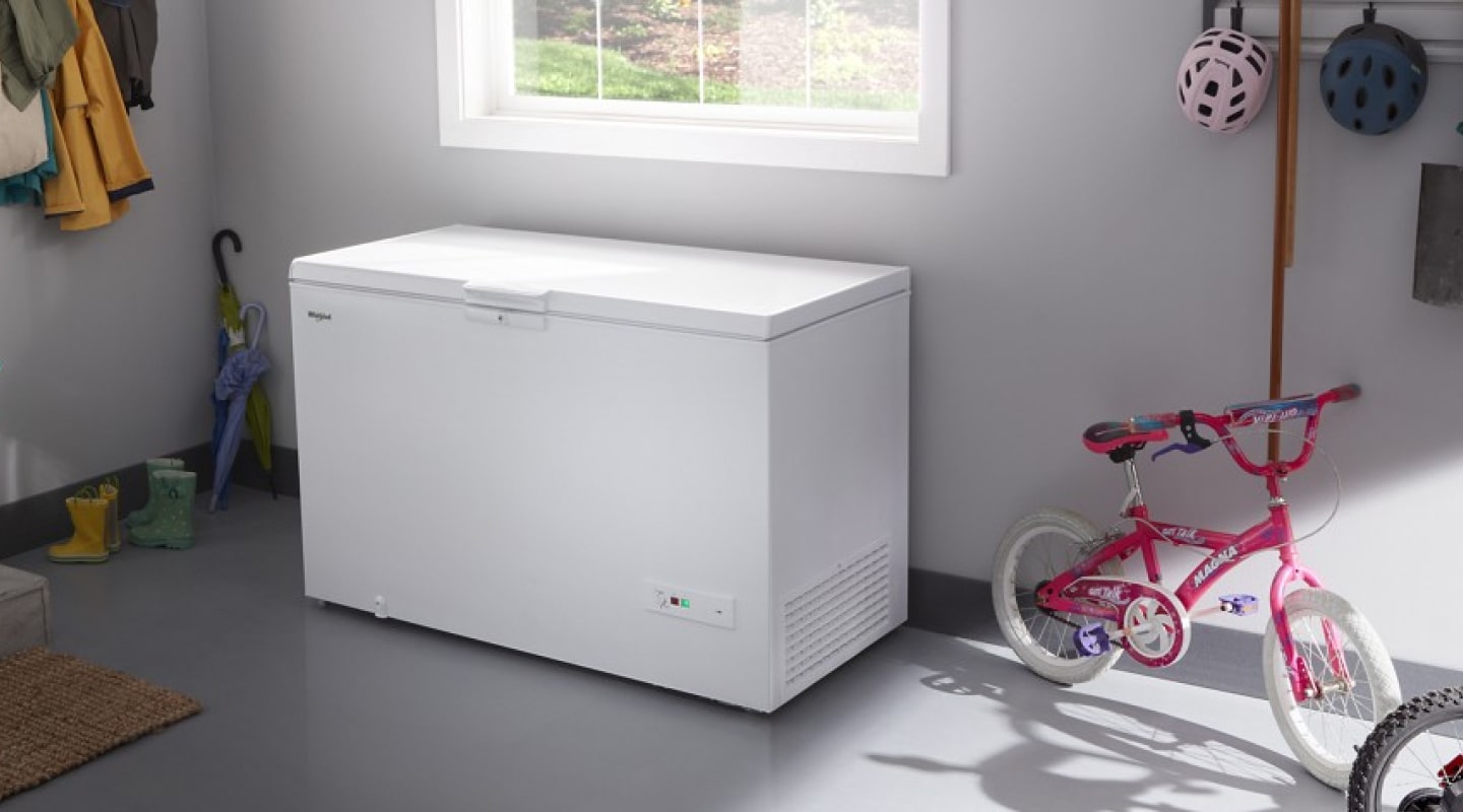 White Whirlpool® Chest Freezer beneath window in garage