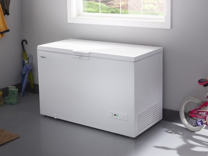 White Whirlpool® Chest Freezer beneath window in garage