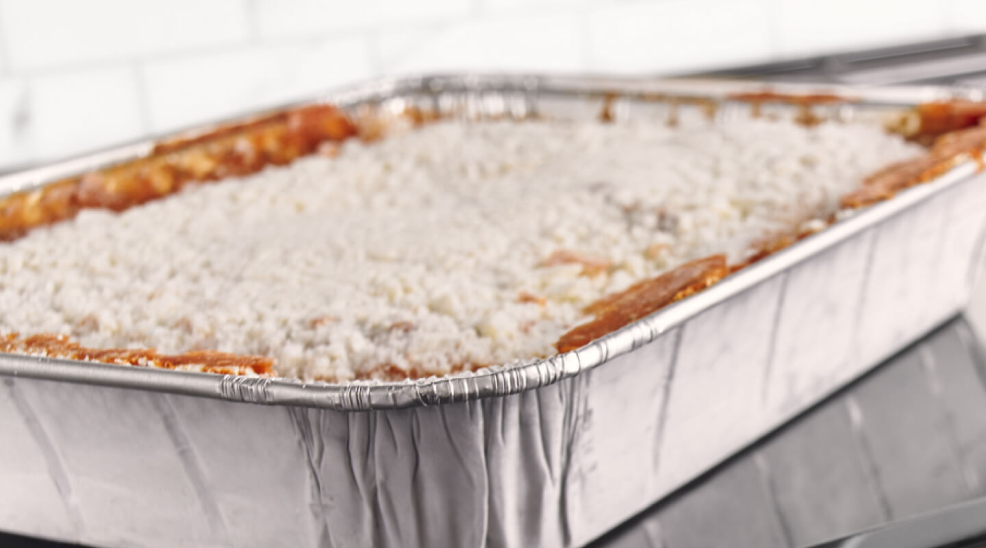 Lasagna in a foil pan getting ready to cook in the oven