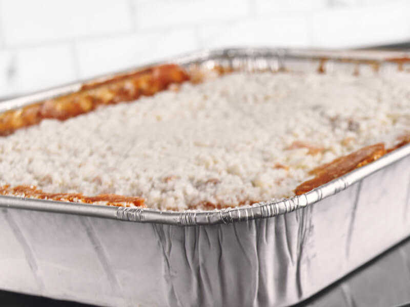 Lasagna in a foil pan getting ready to cook in the oven