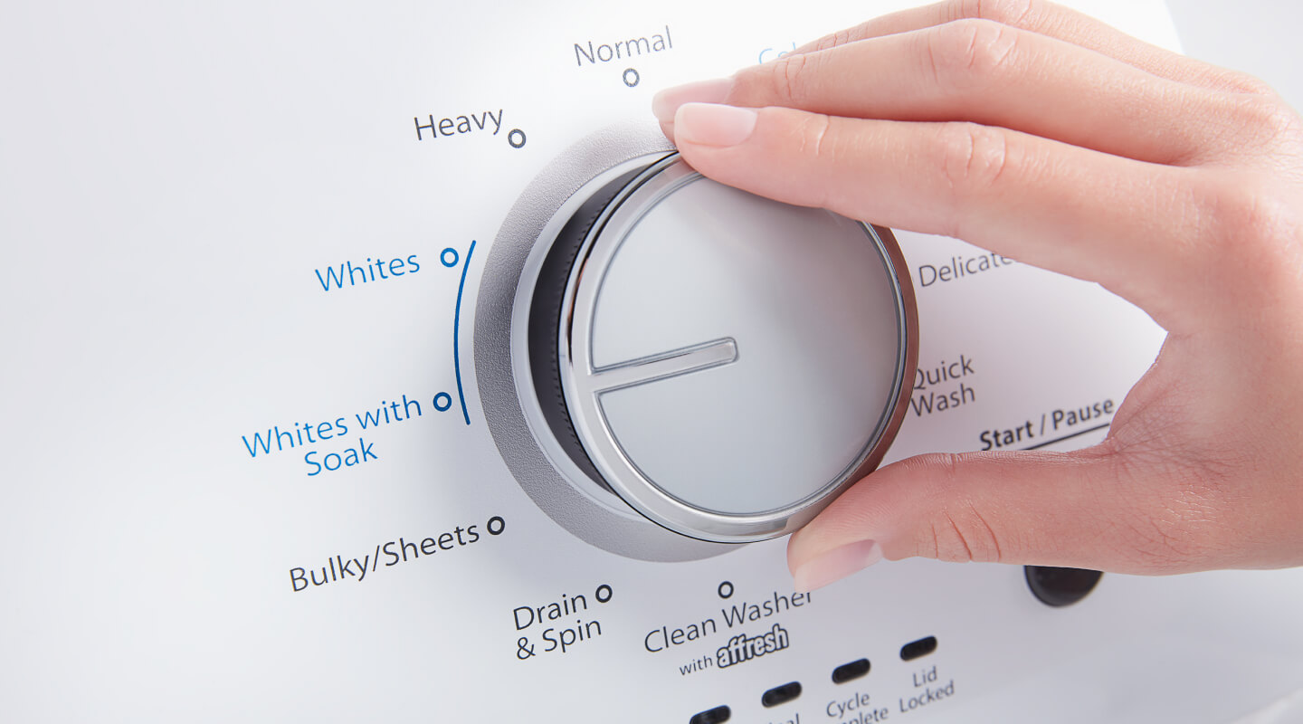 A person adjusting the settings of a washer