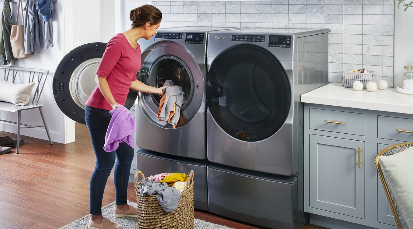 Person loading front load washing machine