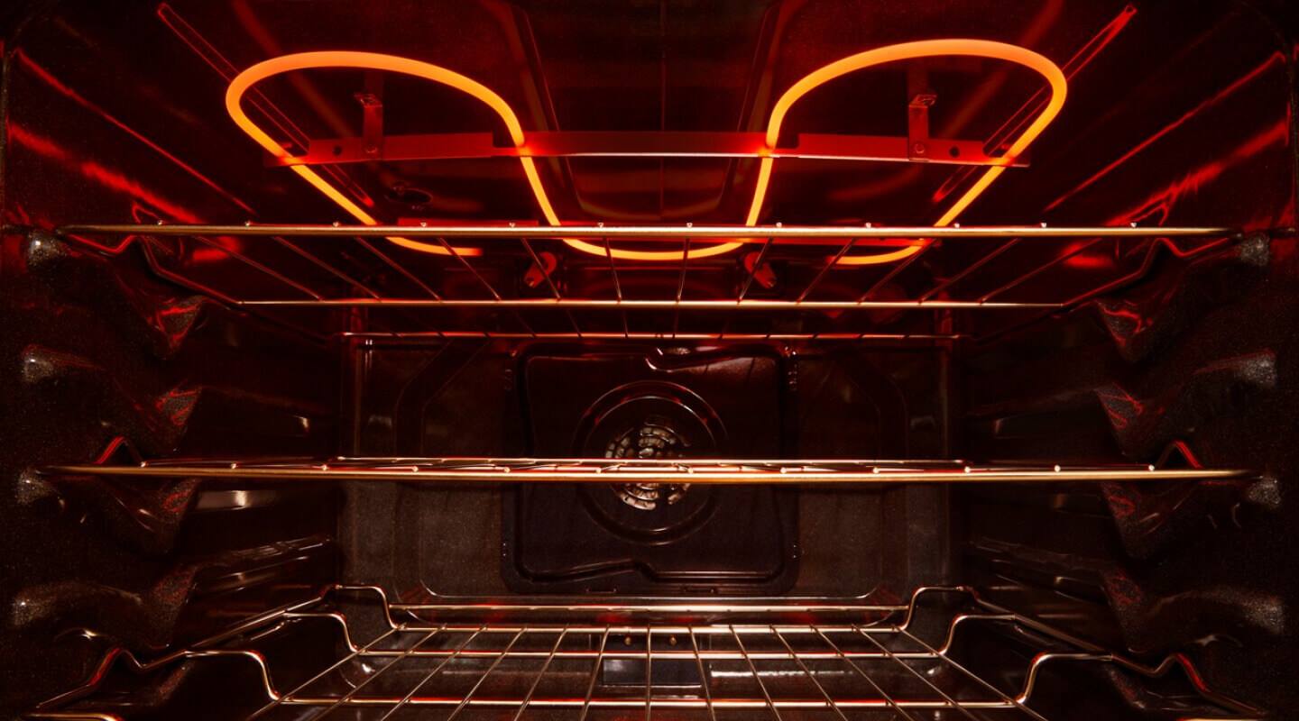 The inside of an oven with three racks