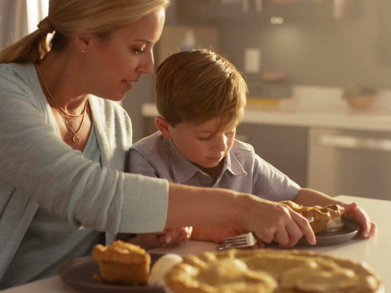 A mom serving her son a slice of pie