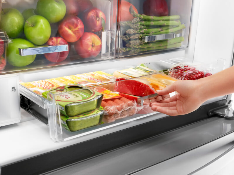 A person pulling out a fridge drawer