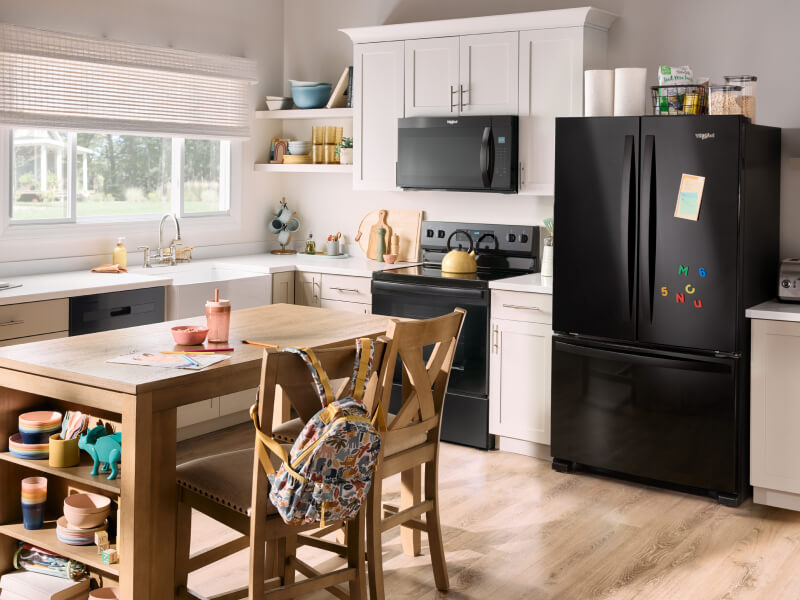 A kitchen with a suite of black Whirlpool® Appliances