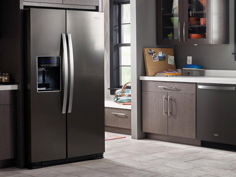 A darker kitchen with a black Whirlpool® Refrigerator and dishwasher