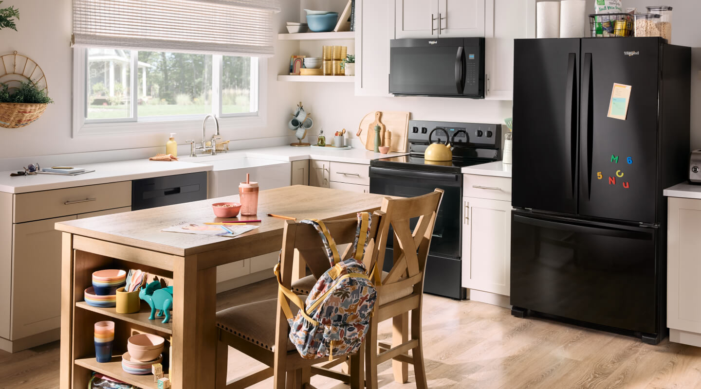 A kitchen with a suite of black Whirlpool® Appliances