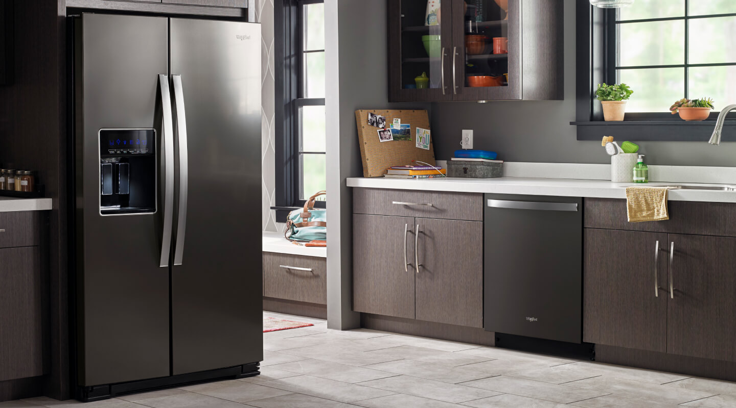 A darker kitchen with a black Whirlpool® Refrigerator and dishwasher
