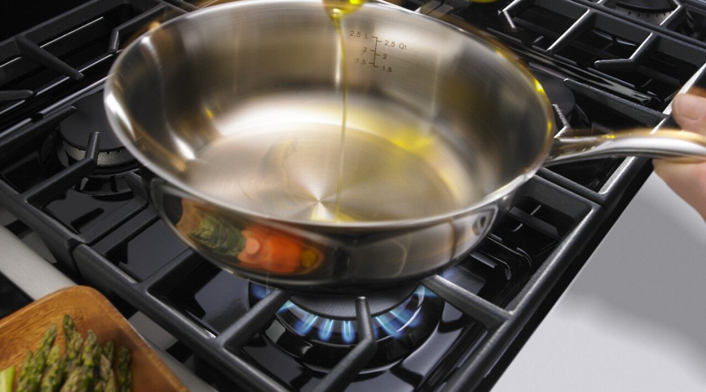 Person pouring oil into a pan