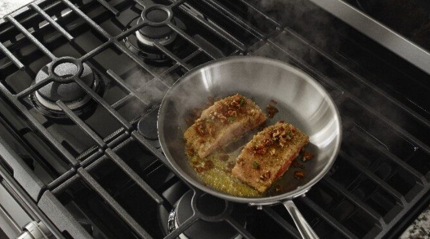 Meat cooking with oil and other garnishes in a pan 