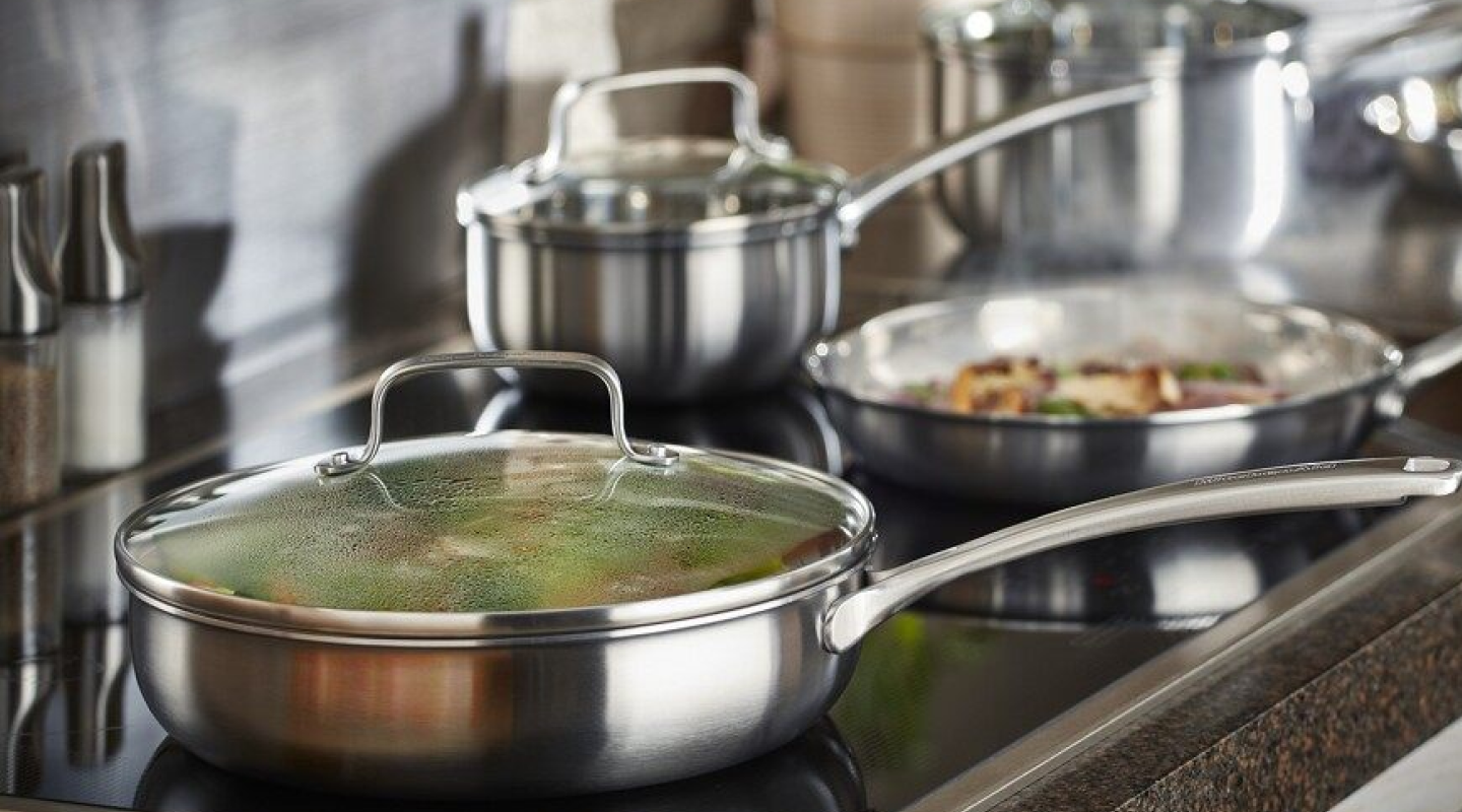 Various pots and pans cooking food on a cooktop