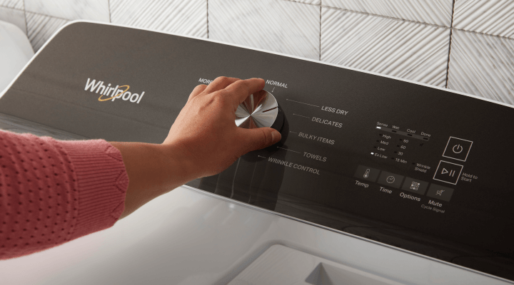 A person selecting a washing machine cycle