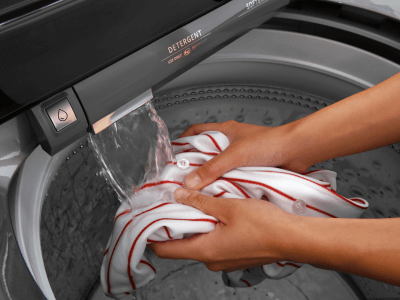 Person rinsing items in a washing machine