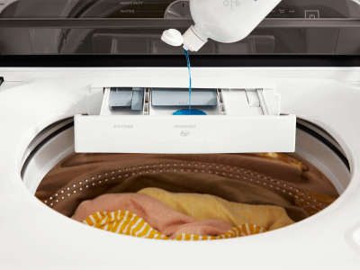 Person adding detergent to a washing machine