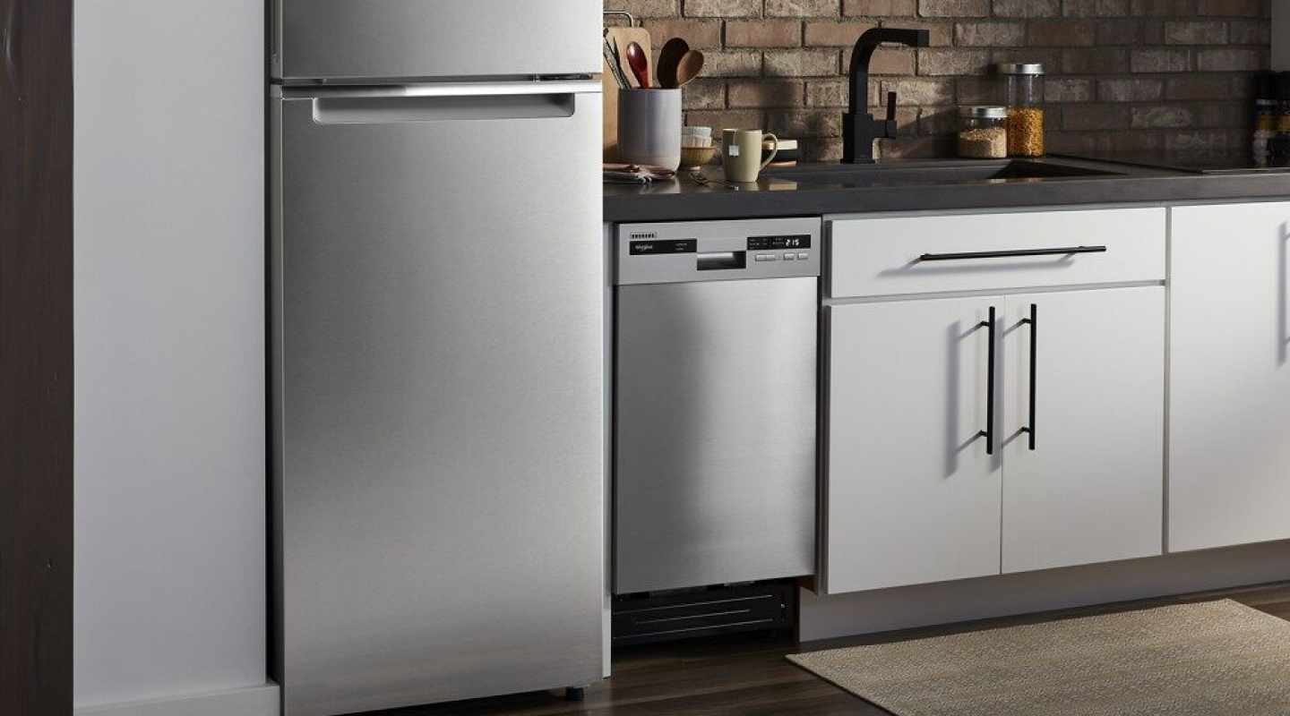Compact stainless steel dishwasher next to stainless steel refrigerator. 