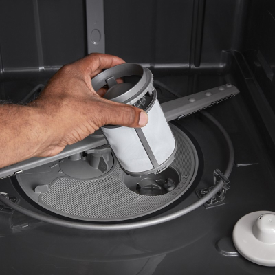 A person pulling a filter out of a dishwasher