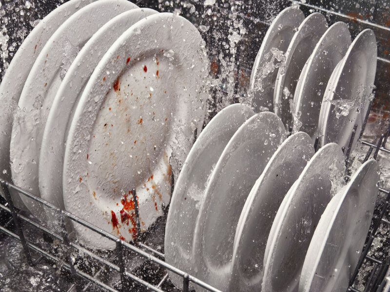 Dirty dishes being cleaned inside a dishwasher