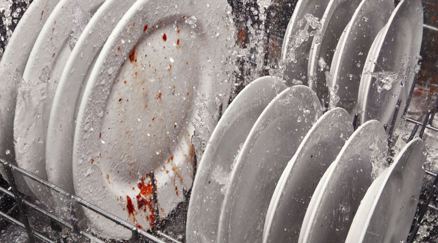 Dirty dishes being cleaned inside a dishwasher