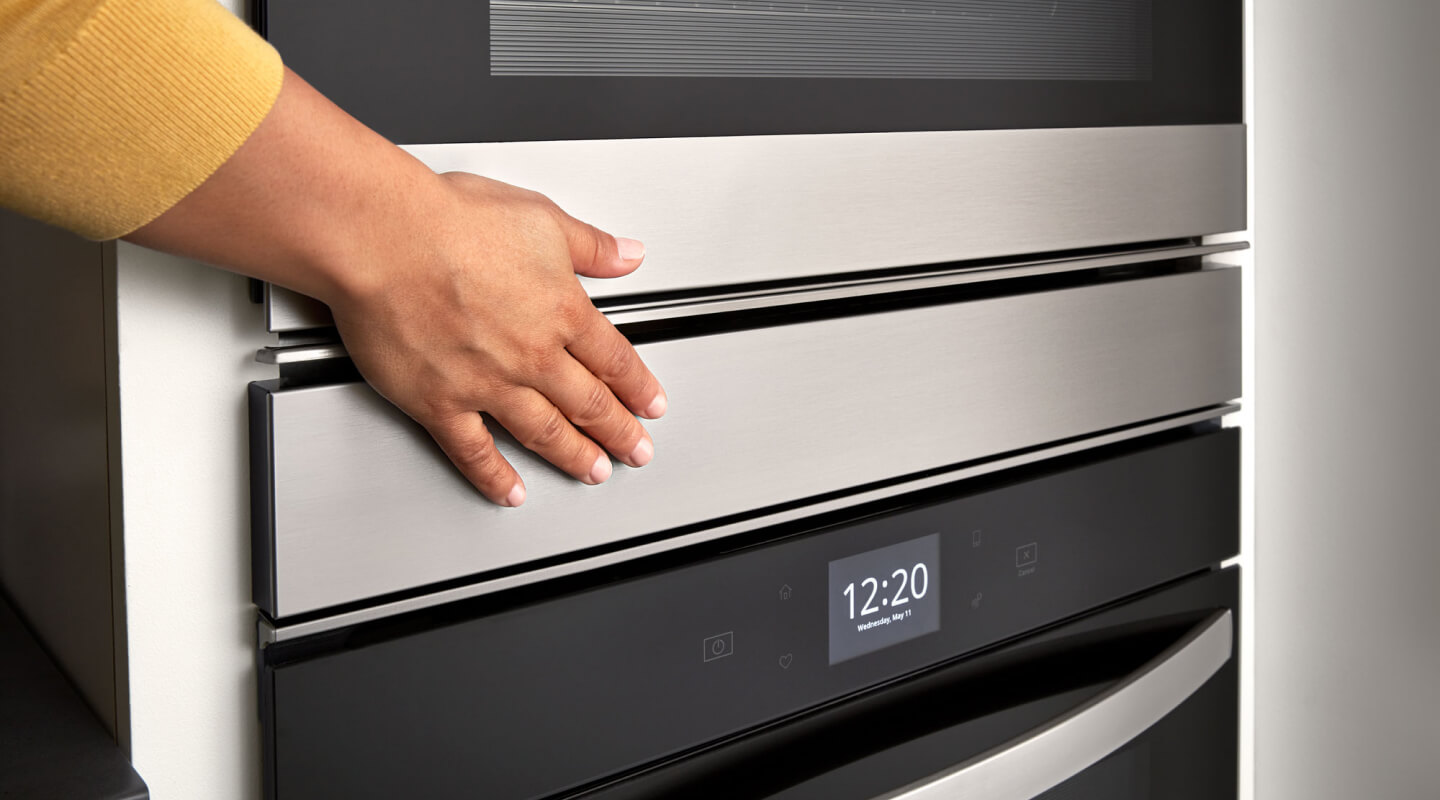 Hand touching a Whirlpool® double wall oven