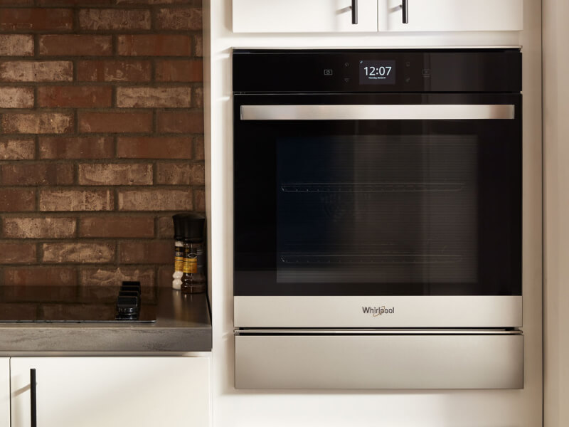 Stainless steel Whirlpool® wall oven in a rustic kitchen
