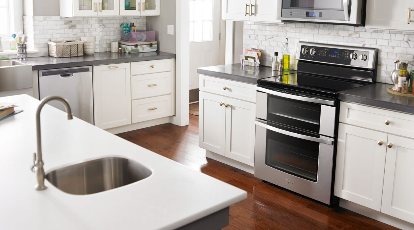 Stainless steel Whirlpool® double oven range inside a bright kitchen